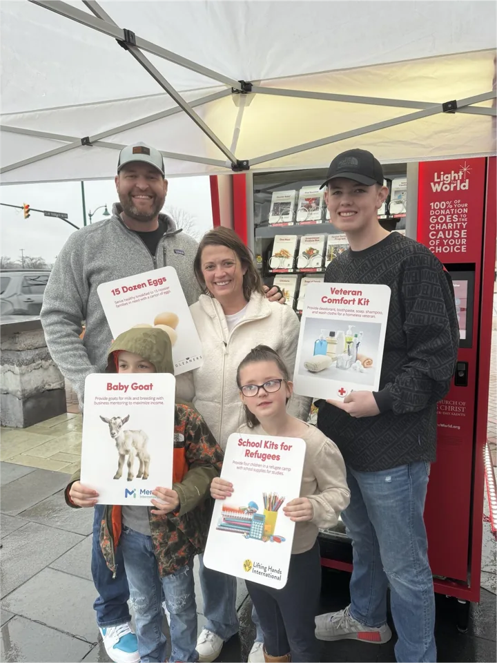 A family holding donation cards at a Giving Machine during a past Indiana season